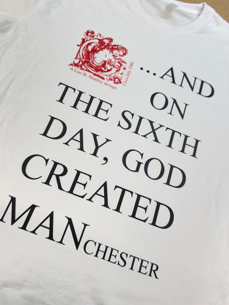 White t-shirt with black text and red logo on a white background
and on the sixth day god created MANchester