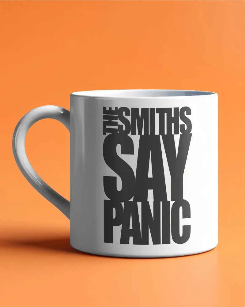 White mug with 'The Smiths Say Panic' text on an orange background